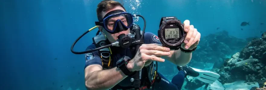 Plongeur sous-marin consultant son ordinateur de plongée au poignet pendant une immersion